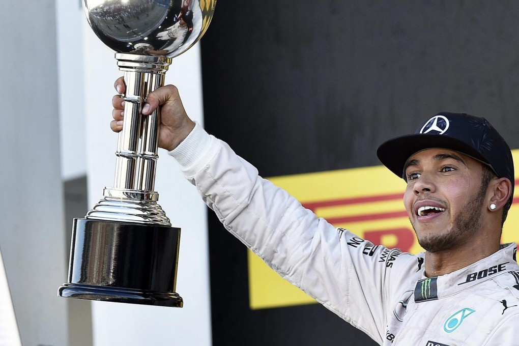 British F1 driver Lewis Hamilton celebrates on the podium after winning the Japanese Formula One Grand Prix at the Suzuka Circuit. Photo: EPA