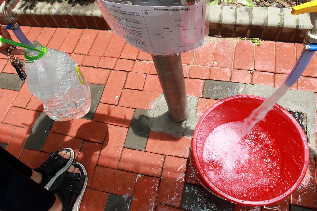 Residents collect fresh water at one of the temporary distribution pipes at Kai Ching Estate. Photo: May Tse