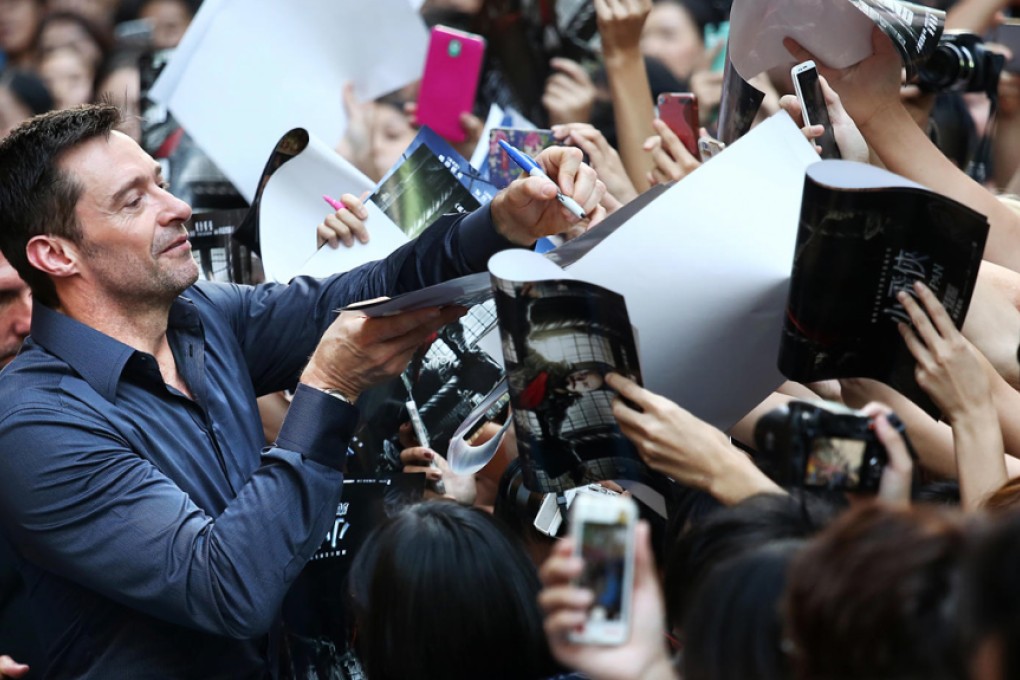 Hugh Jackman signs autographs as he greets his fans in Times Square. Photos: Jonathan Wong