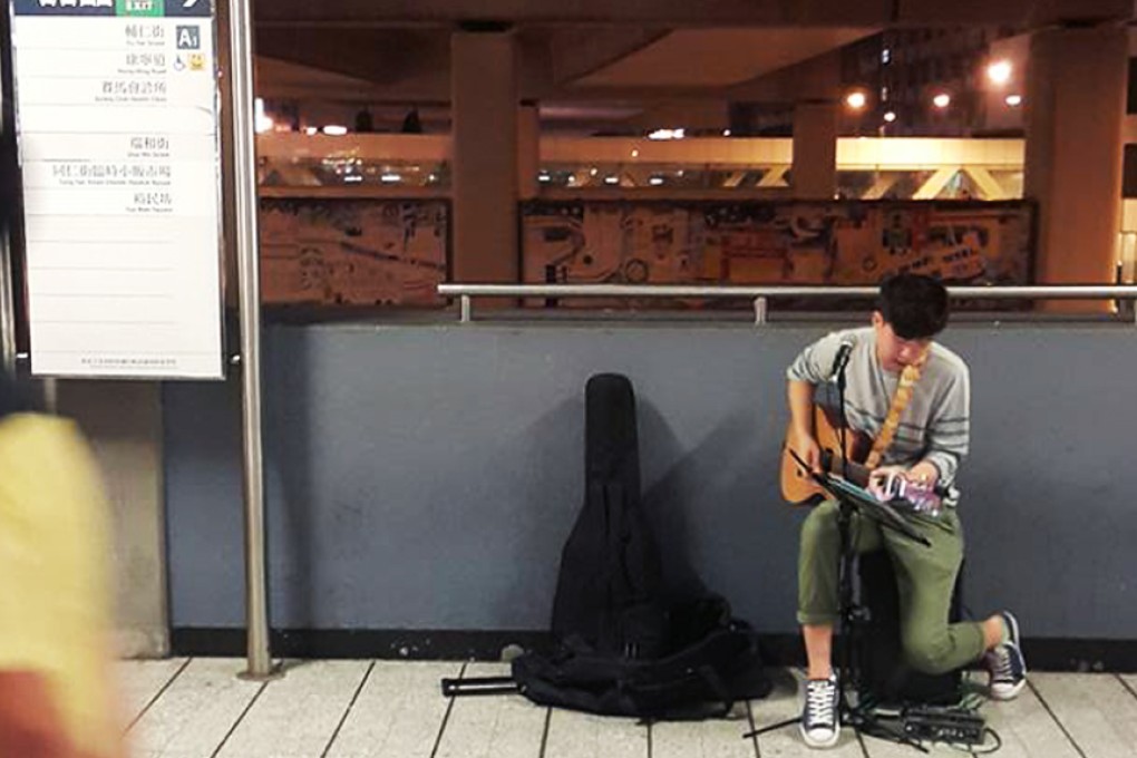 The mystery busker strums and sings in Kwun Tong. Photo: SCMP Pictures