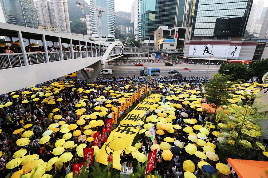 Yellow umbrellas once again make an appearance en masse outside government headquarters in Admiralty today along with a sign that reads “I want true universal suffrage” as rally participants commemorate the Occupy movement for genuine universal suffrage. Photo: Felix Wong