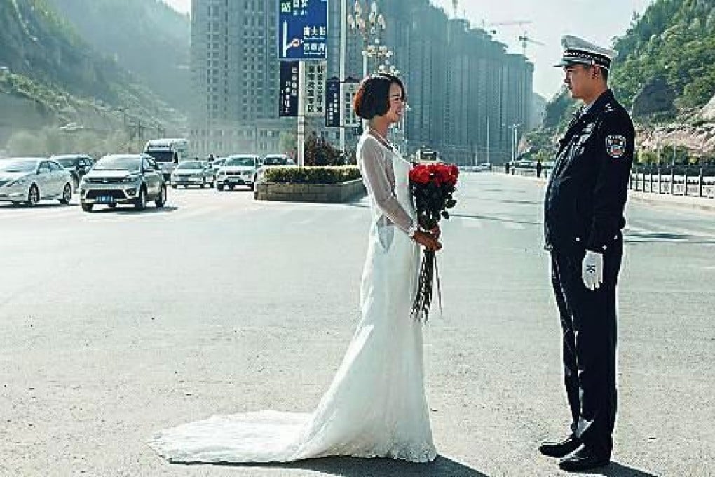 Life in the fast lane: Traffic cop Li Tao was surprised to see his long-suffering fiancee Xiaoyan turn up to work for her wedding gown photo shoot. Photo: Huashang Daily