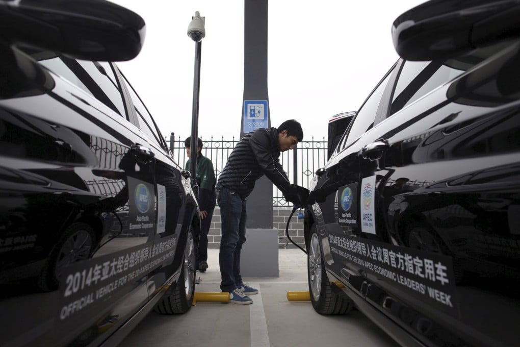 A man charges the batteries of BAIC Motors electric cars in Beijing. Photo: Reuters