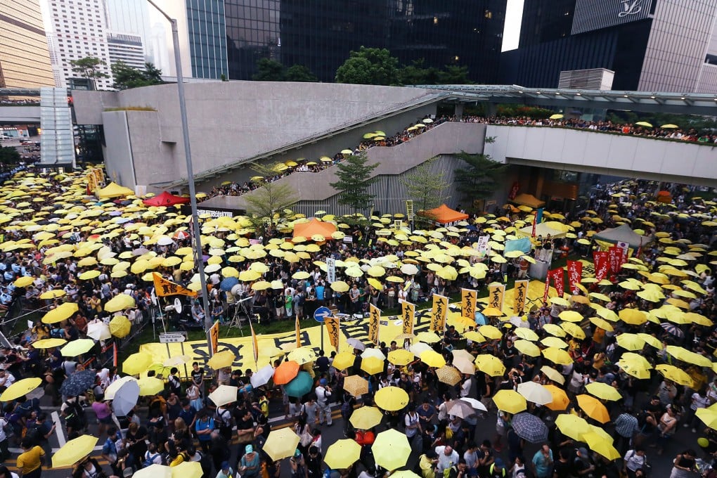 Protesters hold yellow umbrellas outside the government offices in Admiralty. They stood silently for five minutes to reflect on the civil disobedience campaign. Photo: Sam Tsang
