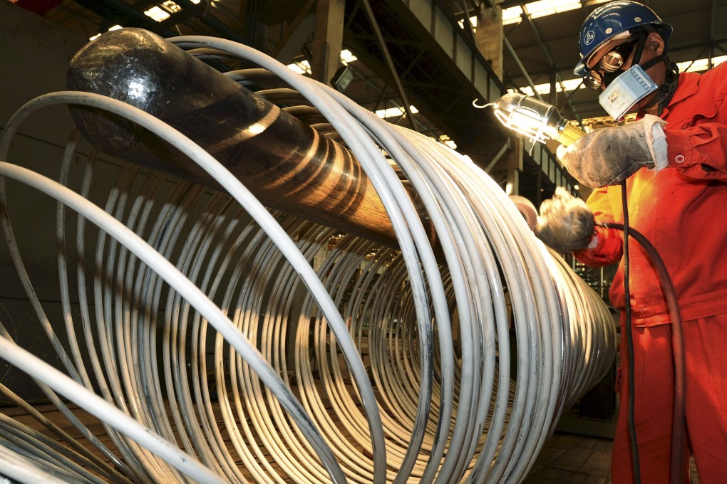 A worker polishes steel coils at a factory in Dalian, Liaoning province, China. Photo: Reuters