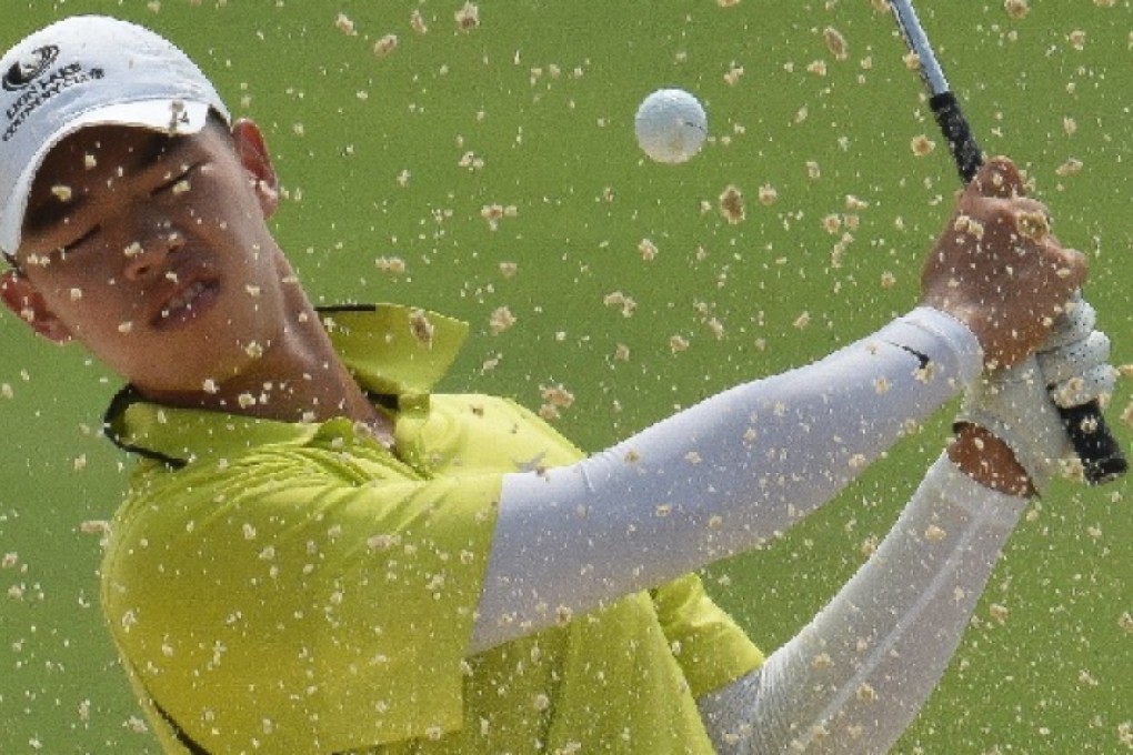 Guan Tianlang blasts out of a bunker at the 13th during a practice round on Wednesday. Photos: SCMP Pictures