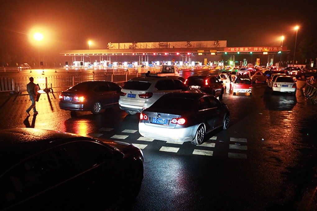 Motorists wait at a Jinghua toll gate, waiting for toll-free use of the highway. Photo; SCMP Pictures