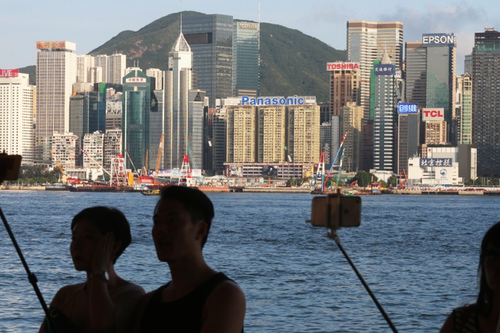Tourists capture the Hong Kong skyline. Young technology companies say there is a very small talent pool of skilled web developers, and too much competition from bigger players in the market. Photo: K.Y.Cheng