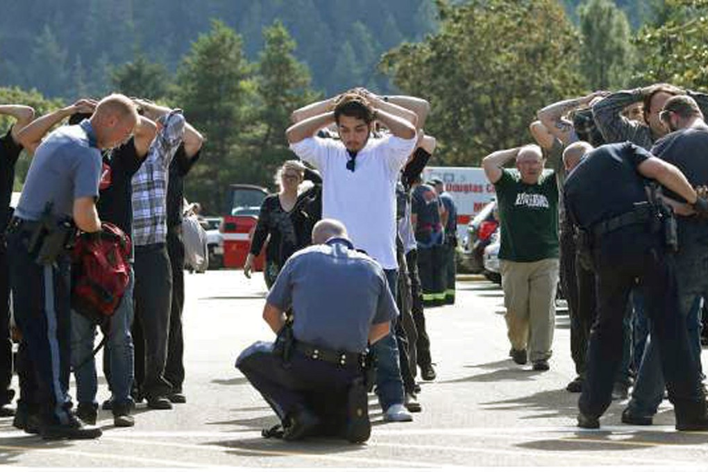 Police search students outside Umpqua Community College in Roseburg. Photo: AP
