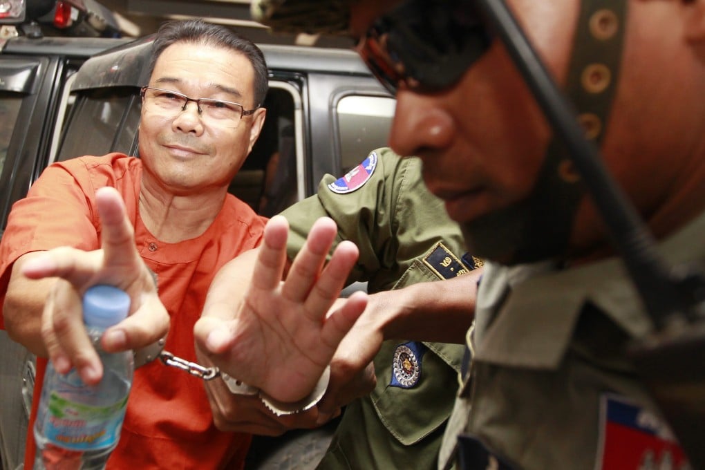 Cambodian opposition Senator Hong Sok Hour of the Sam Rainsy Party is escorted by police officers at the Municipal Court in Phnom Penh. Photo: EPA