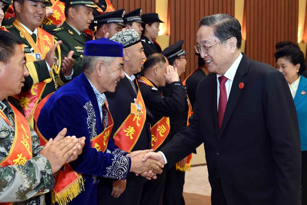 Yu Zhengsheng, chairman of the National Committee of the Chinese People's Political Consultative Conference, shakes hands with representatives from the Xinjiang Uygur autonomous region before addressing a rally in Urumqi on Thursday marking the 60th anniversary of the autonomous region's founding. Photo: Xinhua