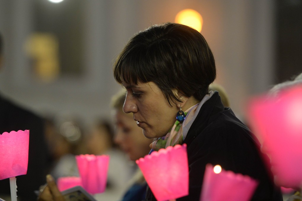 A woman takes part in a vigil prayer on the eve of the XIV General Assembly of the Synod of Bishops at St Peter's basilica at the Vatican. Photo: AFP