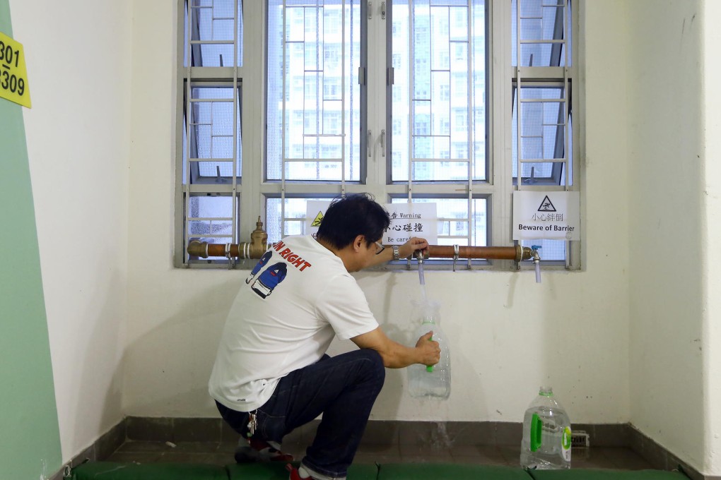 A man fetches water from newly installed temporary pipes at Yan Ching House in Kai Ching Estate yesterday. Photo: Sam Tsang