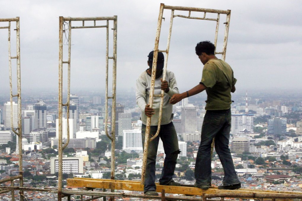 Dangerous work in Jakarta. Some are wondering if regional foreign exchange reserves are a sufficient safety net. Photo: Reuters
