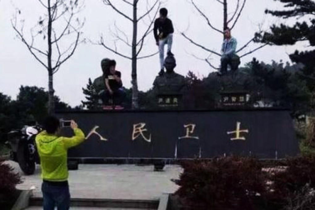 A photo of Chinese tourists posing disrespectfully with statues of firefighters who had lost their lives in an industrial park fire in Zhejiang, sparked anger online. Photo: SCMP Picture