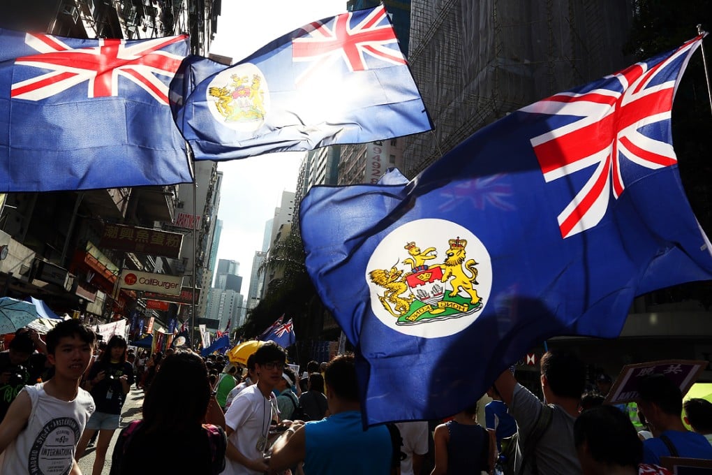 Protesters wave British colonial-era flags during a pro-democracy march. While they are a fringe group, they're ruffling feathers in Beijing. Photo: Felix Wong