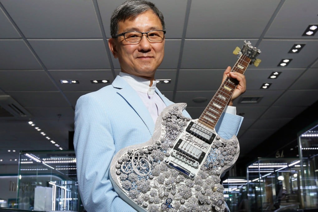 Jeweller Aaron Shum shows off his gold and diamond guitar creation. Photo: Edmond So