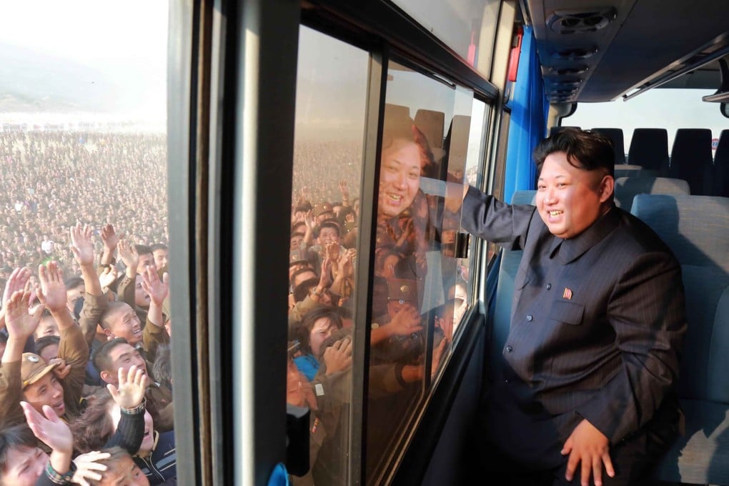 North Korean leader Kim Jong-Un waves to a crowd from a bus while inspecting a newly-built village at Paekhak-dong in Sonbong District. Photo: AFP