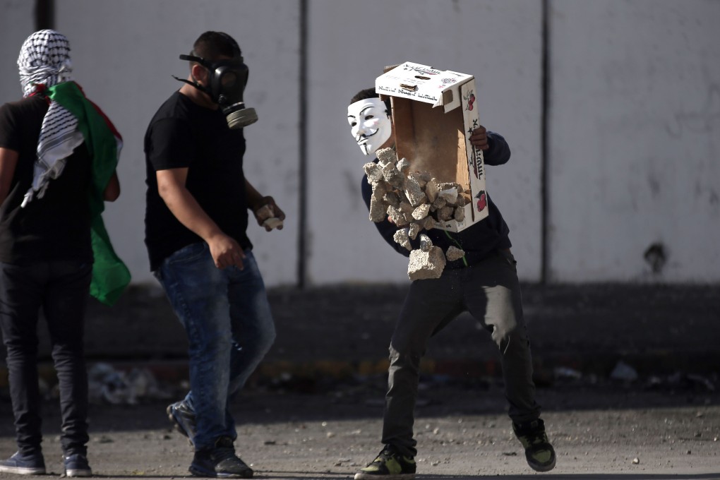 Palestinian demonstrators gather a pile of stones to throw towards Israeli security forces during clashes in the Palestinian neighborhood of Shuafat refugee camp in east Jerusalem on Friday. Photo: AFP