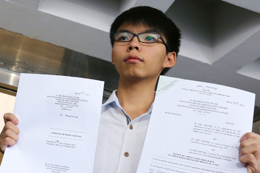 Scholarism convenor Joshua Wong shows his application to the High Court seeking a judicial review of the age restriction on legislative election candidates. Photo: Felix Wong