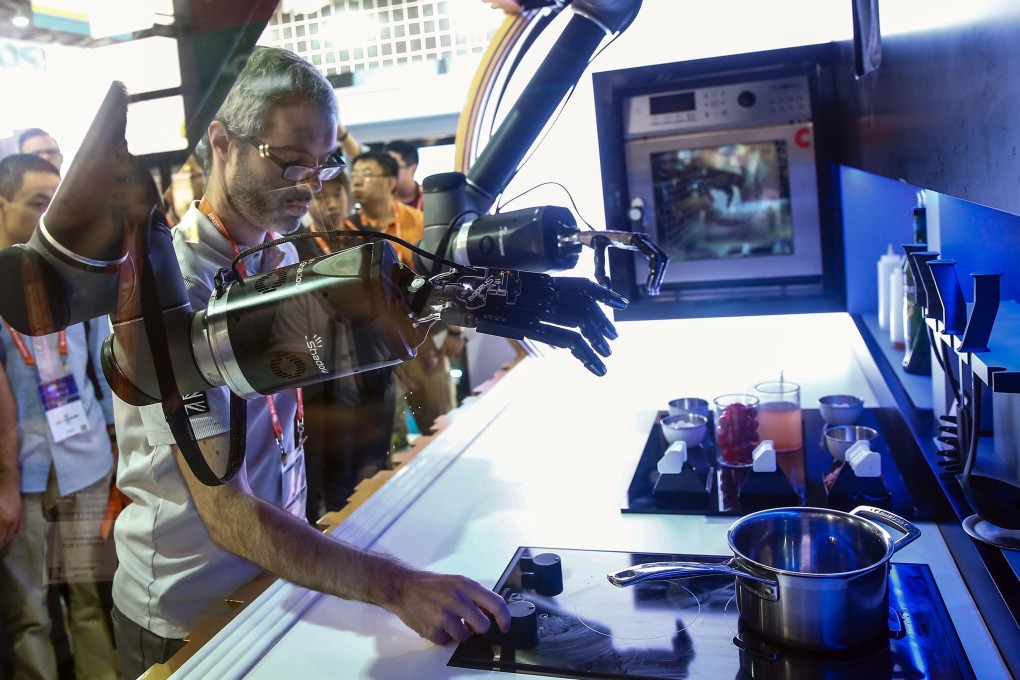 An exhibitor demonstrates a robot to visitors during the first Consumer Electronics Show (CES) in Asia in Shanghai on May 25. China is focusing more on domestic consumption, high technology and innovation as it looks to wean itself off exports and state-led investment growth. Photo: AFP