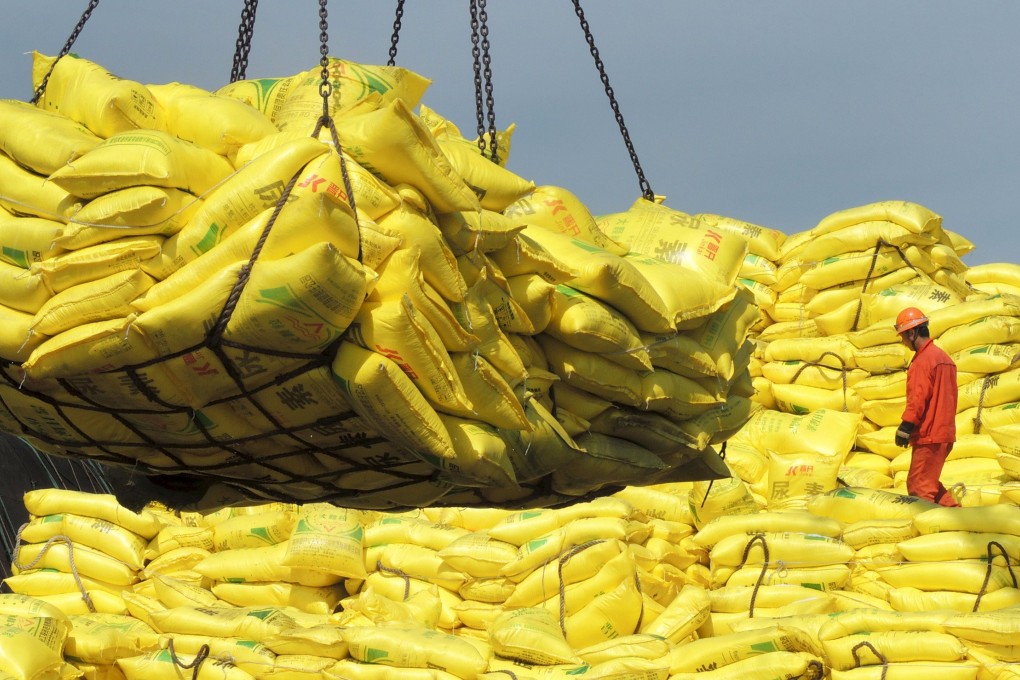A worker stands on piles of industrial products ready for export at a port in Lianyungang, China. Photo: Reuters