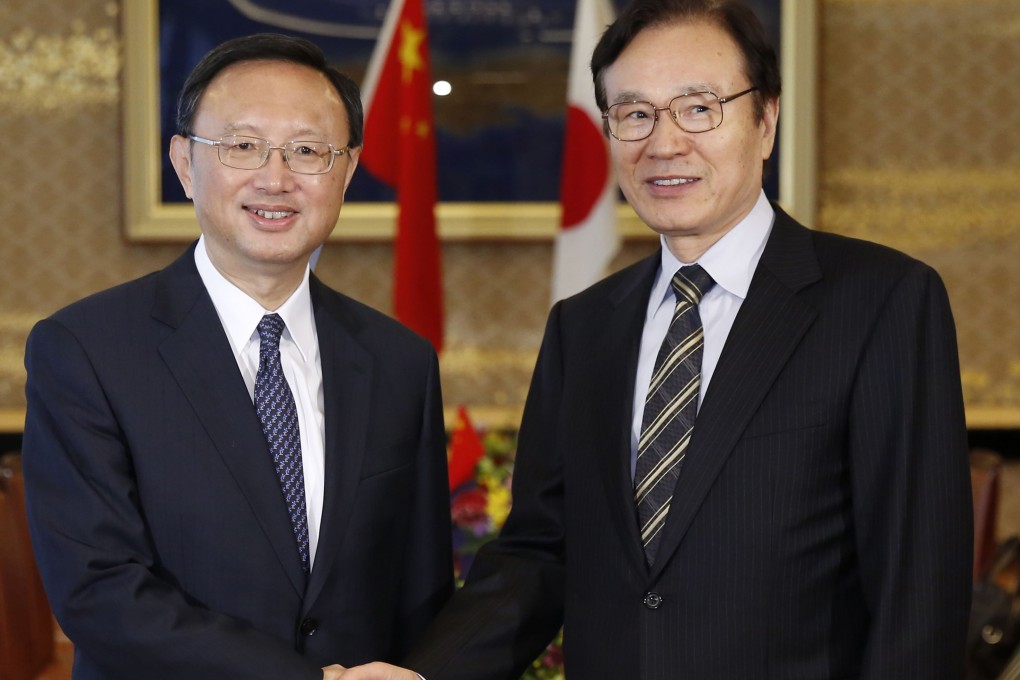China's State Councillor Yang Jiechi (left) shakes hands with Japan's National Security Council head Shotaro Yachi at the start of their talks in Tokyo on Tuesday. Photo: AFP