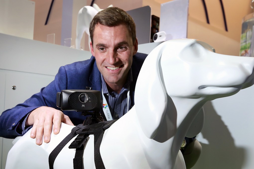 Binatone Global Group Chief Commercial Officer Neil Scanlon poses with "smartphone" for dogs at Hong Kong Electronics Fair at Hong Kong Convention and Exhibition Centre in Wan Chai. Photo: Nora Tam