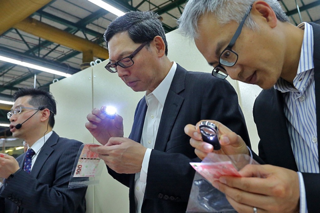 Chief executive of Hong Kong Monetary Authority Norman Chan Tak-lam(centre) with Executive Director (Monetary Management) Howard Lee, inspect bank notes at the Hong Kong Note Printing Limited. Photo: SCMP Pictures