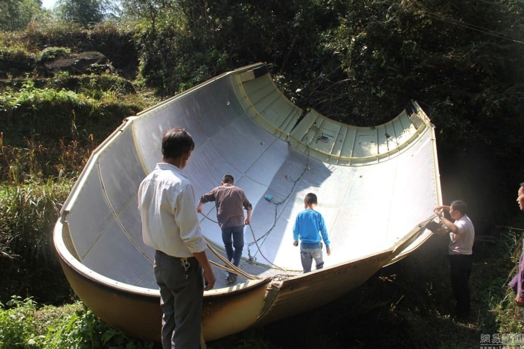 Farmers inspect the piece of space rocket that fell into their fields in Yuanxi village in Jiangxi province. Photos: SCMP Pictures