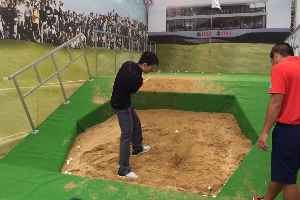 A member of the public tries a 'Rory McIlroy' bunker shot at Chater Garden. Photo: SCMP Pictures