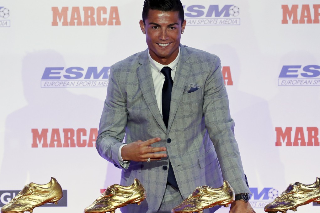 Real Madrid's striker Cristiano Ronaldo poses in front of his four Golden Boot trophies during a ceremony in Madrid, Spain, October 13, 2015. Ronaldo was awarded the European Golden Shoe trophy for a record fourth time at a ceremony in Madrid on Tuesday. The Portuguese picked up the trophy for his 48 goals from 35 appearances for Real, just edging out Barcelona's Lionel Messi who netted 43 goals in 38 outings. Photo: Reuters