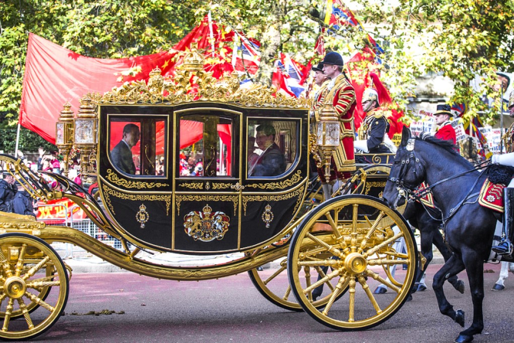 Chinese President Xi Jinping in a gilded carriage cruises past Falun Gong supporters on his way to his meeting with Queen Elizabeth II. Photo: AFP