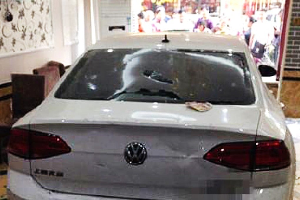 The Chinese driver reversed her car through a window by accident after pressing the accelerator too hard. Photo: SCMP Pictures