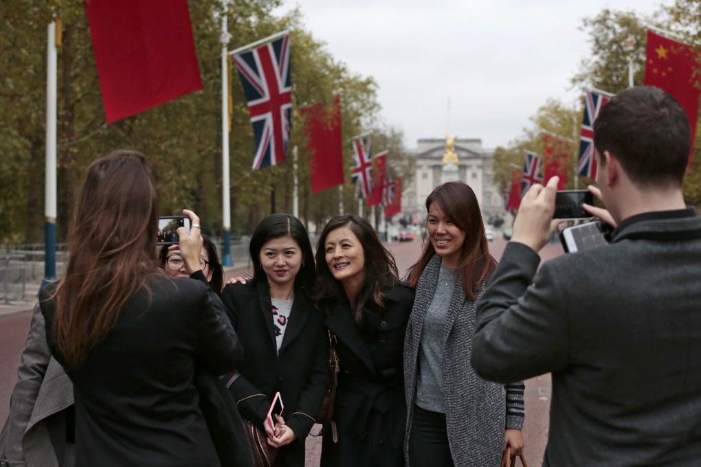 Tourists pose for a photograph near Buckingham Palace in London ahead of President Xi Jinping's state visit to the UK. Photo: Reuters