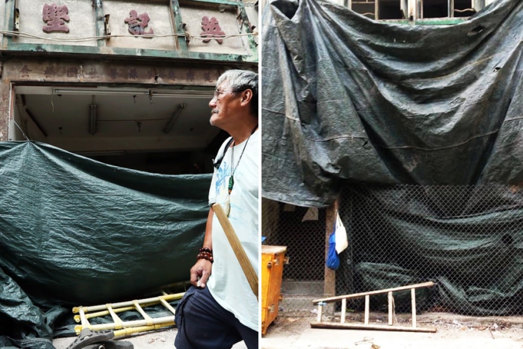 Now you see it ... heritage restoration expert Wong Hung-keung walks past the old shop front in Peel Street, which was then covered up on Thursday. Photos: Nora Tam