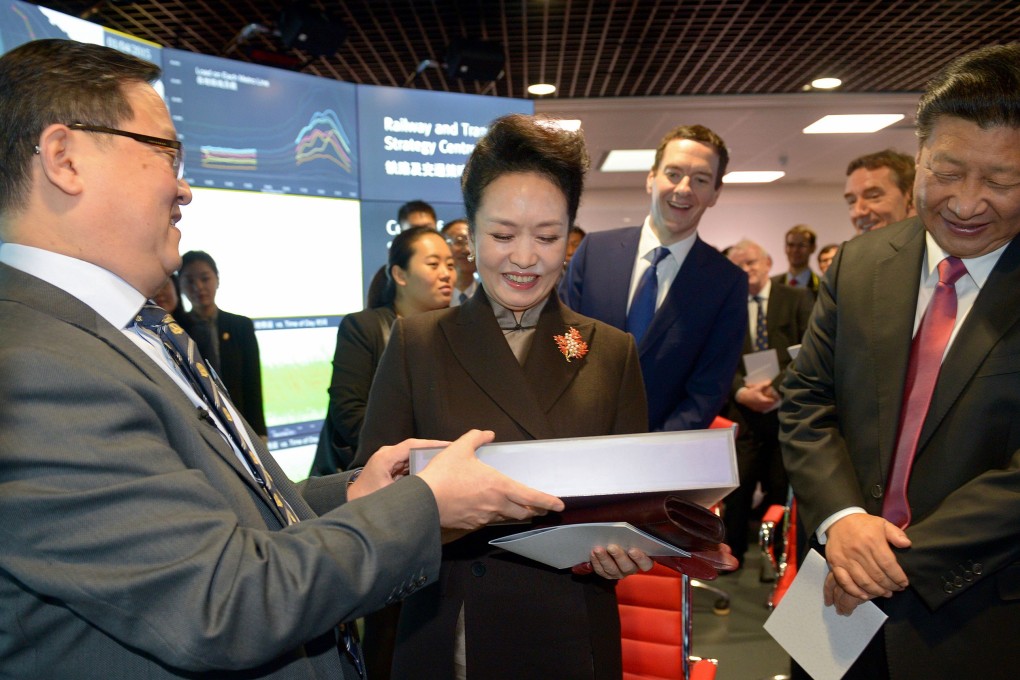 British Chancellor of the Exchequer George Osborne, and Chinese President Xi Jinping react as Professor of Computing Science Yike Guo hands a gift to Chinese First Lady Peng Liyuan during a visit to Imperial College London. Photo: AFP