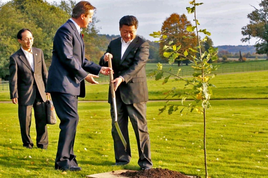 Chinese President Xi Jinping (R) and British Prime Minister David Cameron (2nd R) plant an oak tree symbolizing the China-Britain friendship in Cameron's country retreat, Chequers. Photo: Xinhua