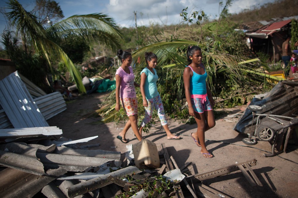Girls walk among debris after the passage of Hurricane Patricia, in La Huerta. Photo: Xinhua