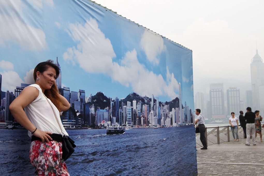 A tourist poses for a photo at the Tsim Sha Tsui promenade. Photo: Sam Tsang