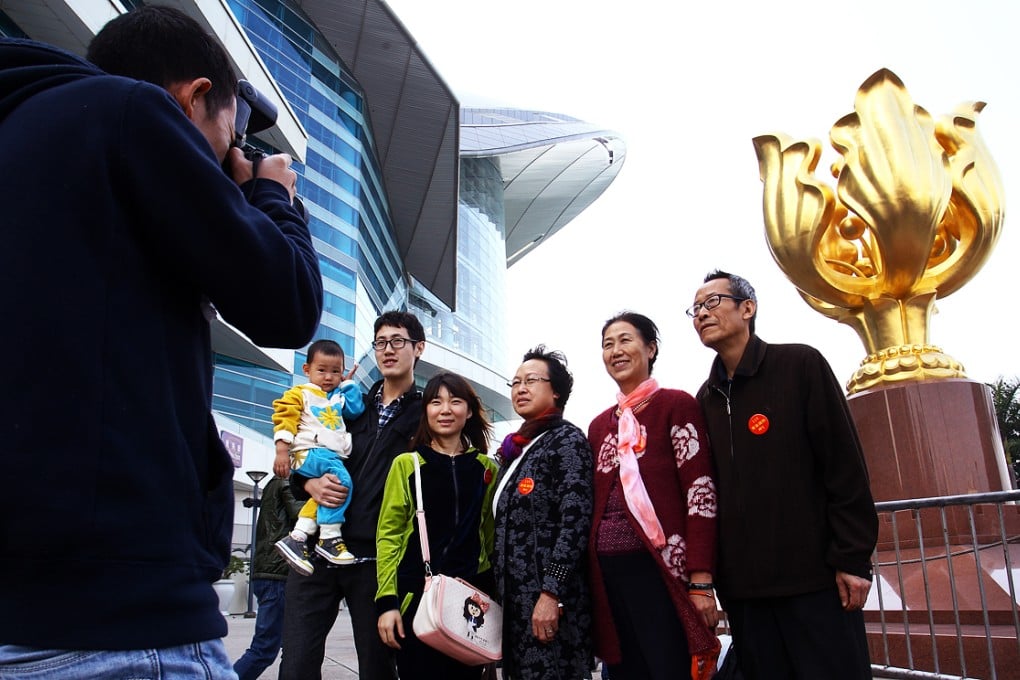 Mainland travelers pose for a picture at Golden Bauhinia Square in Wan Chai. Photo: Dickson Lee
