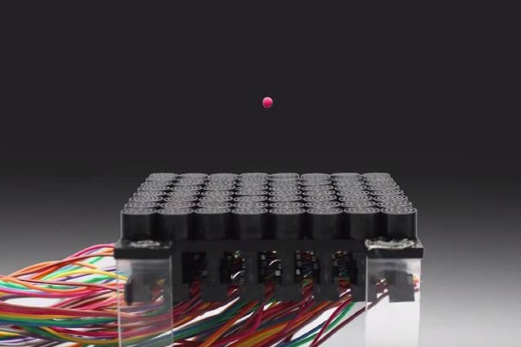 A small ball is seen floating above an array of tiny speakers, held in place by a sonic tractor beam. Photo: Asier Marzo