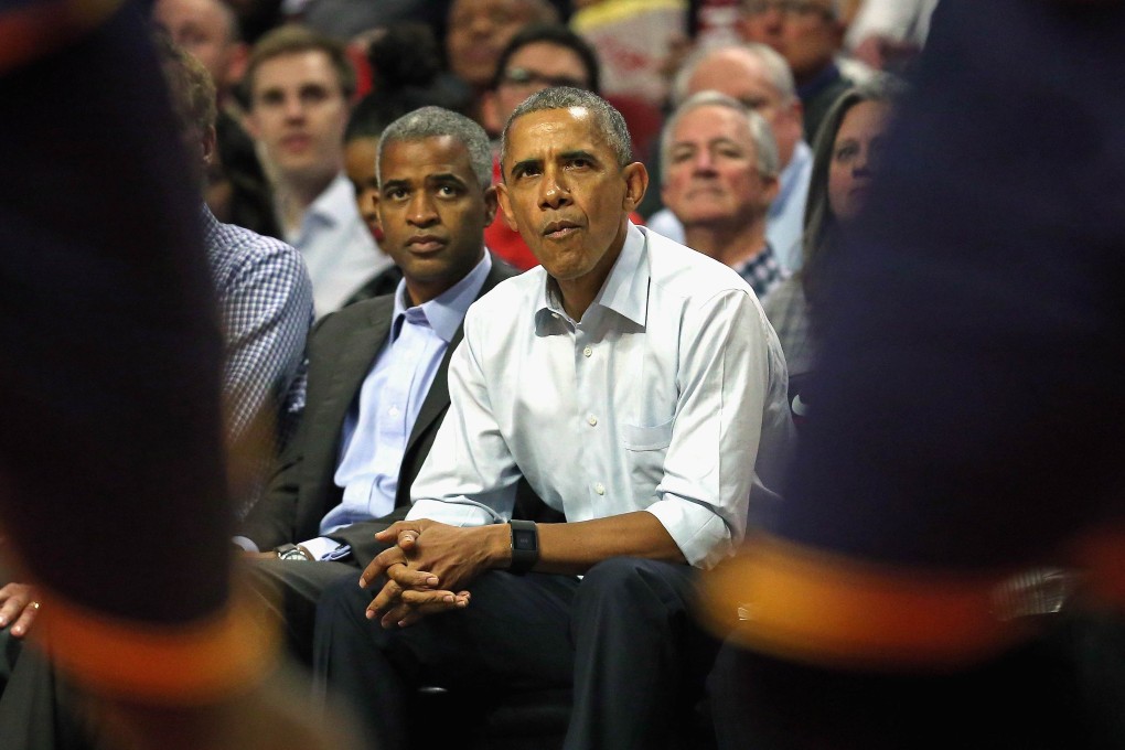 Barack Obama watches from courtside. Photo: AFP