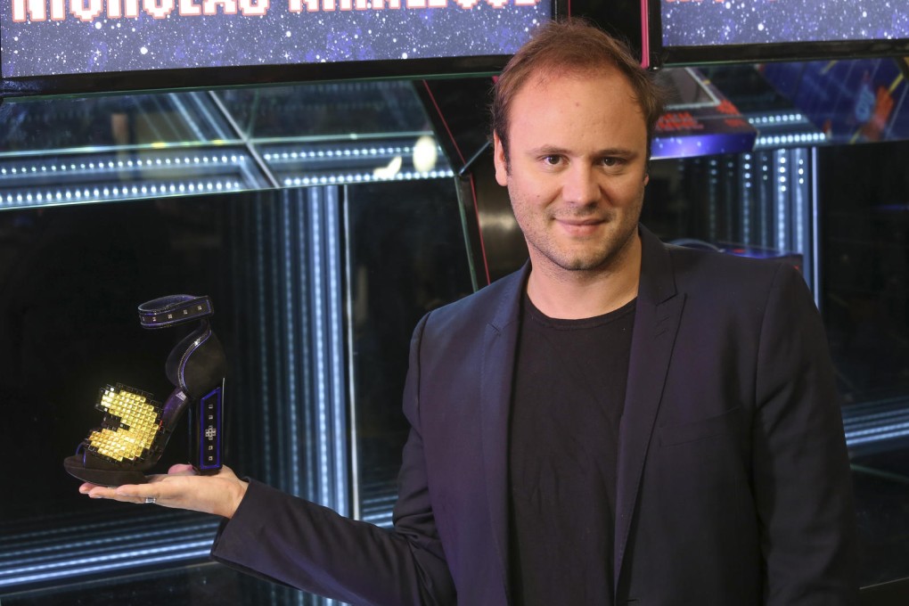 Nicholas Kirkwood, holding a Pac-Man inspired creation.