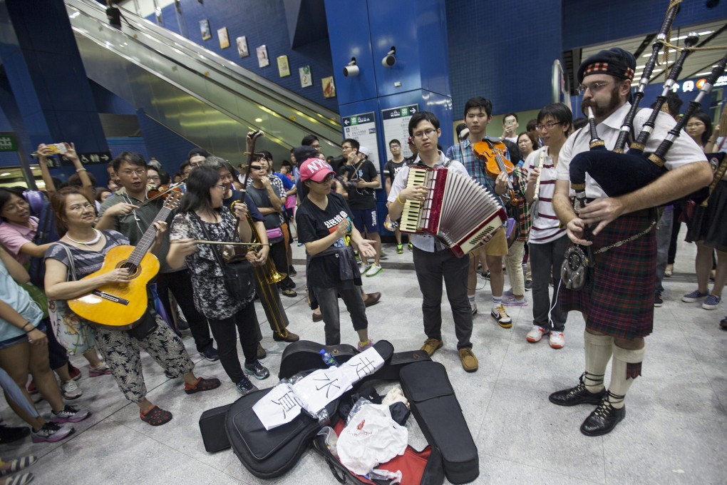 Musicians perform at the Tai Wai MTR station to protest against the company's crackdown on larger instruments. Photo: EPA