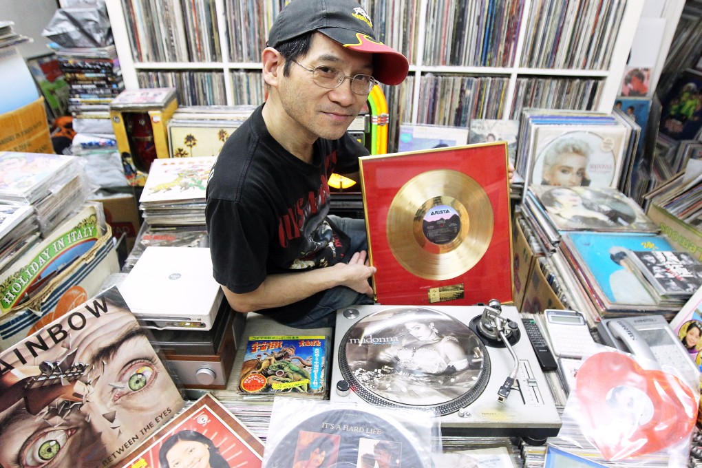 Paul Au surrounded by some of the vinyl he sells at his store in Sham Shui Po.