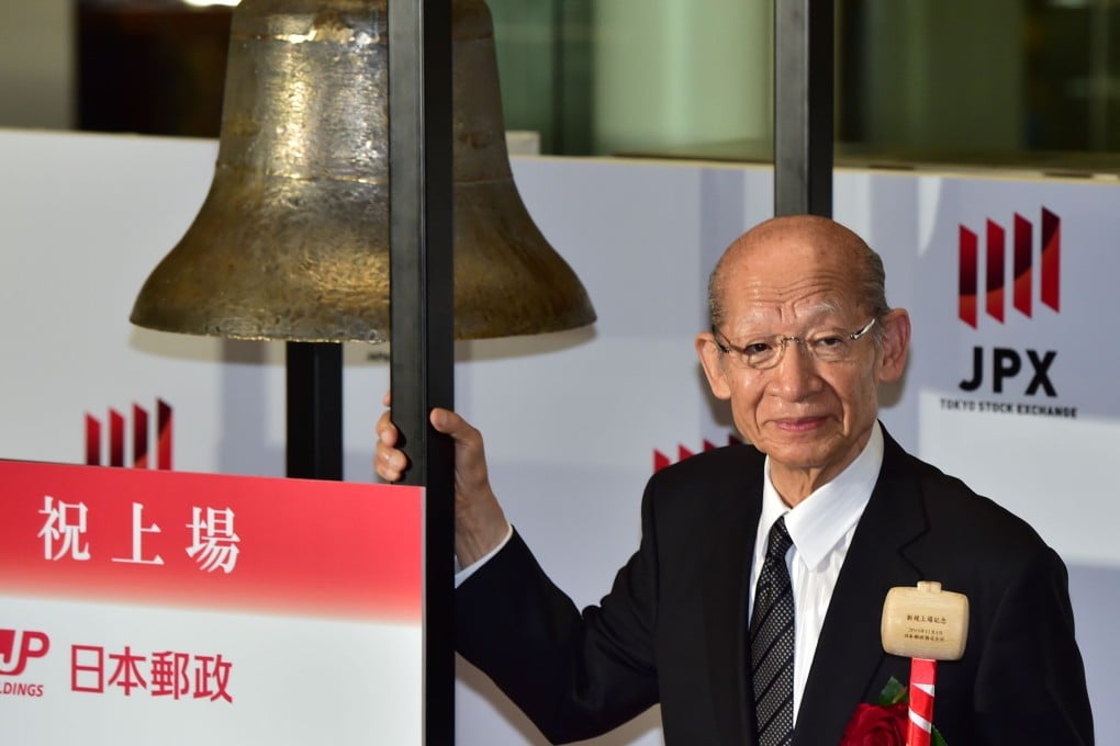 Japan Post Holdings president Taizo Nishimuro rings a bell to mark the listing of the company on the Tokyo stock exchange. Photo: AFP