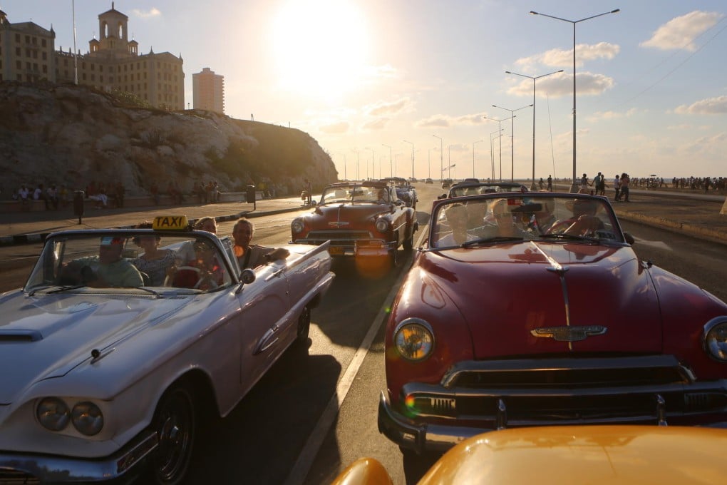 Classic cars cruise through Vedado, in Havana.