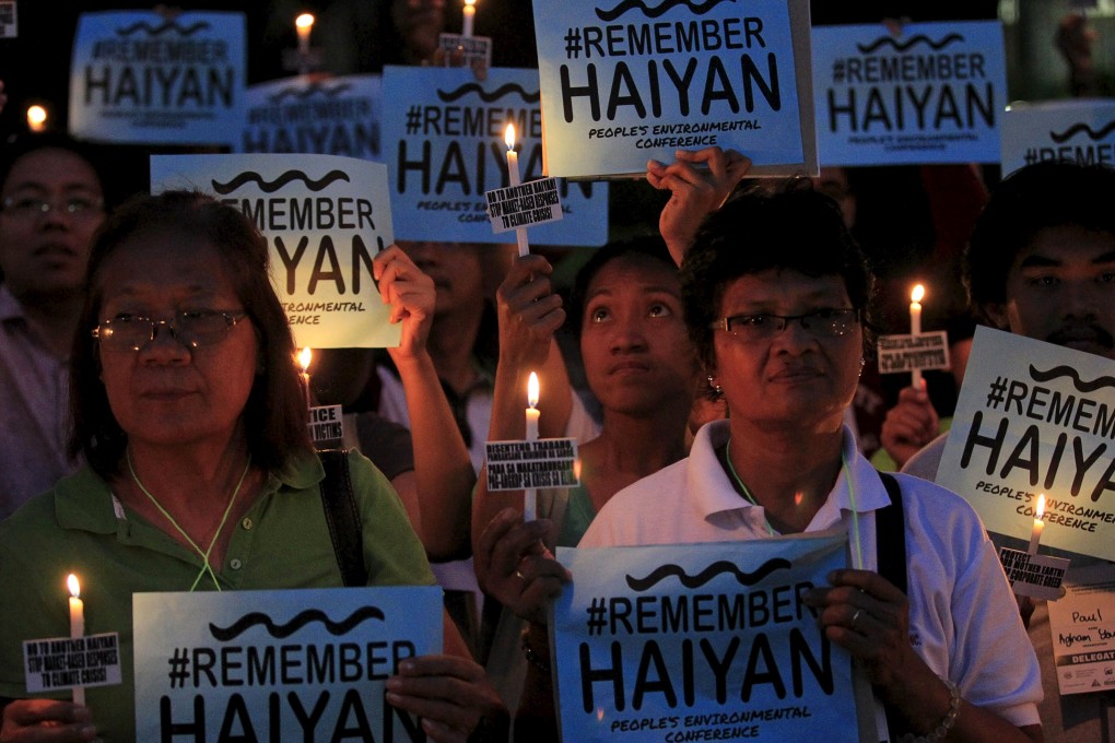 Activists hold placards and candles during a candlelight protest calling on the government to continue support for victims ahead of the second anniversary of the devastating typhoon Haiyan. Photo: Reuters