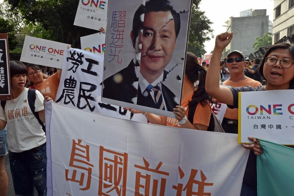 Taiwanese protesters chant slogans as they hold up banners and posters in Taipei yesterday. Photo: AFP